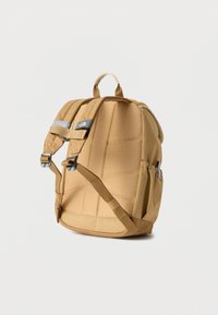 Καφέ σακίδιο με επενδυμένη πλάτη, ρυθμιζόμενους ιμάντες ώμου, πλαϊνή τσέπη και χειρολαβή στο πάνω μέρος σε λευκό φόντο.