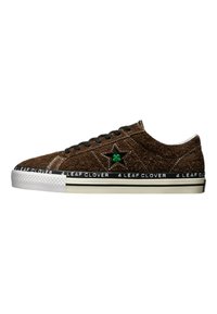Brown sneakers with a textured upper, featuring green clover emblem, black laces, rubber sole, and white accents with "4 LEAF CLOVER" text.