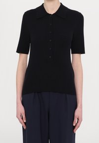 Czarna, prążkowana koszulka polo z krótkim rękawem, okrągłym kołnierzykiem i zapinana na sześć pasujących guzików.