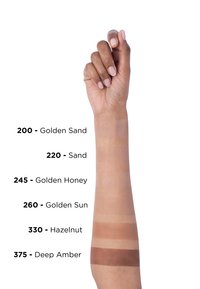 Des échantillons sur un avant-bras montrent six teintes de fond de teint : 200 Sable Doré, 220 Sable, 245 Miel Doré, 260 Soleil Doré, 330 Noisette, 375 Ambre Profond.
