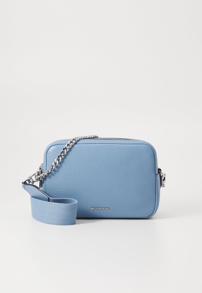Sac bandoulière en cuir bleu clair avec chaîne argentée et sangle en tissu, forme rectangulaire, logo Michael Kors au centre devant.