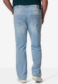 Jeans de color azul claro con un corte relajado, piernas rectas, dos bolsillos traseros y una cinturilla elástica para mayor comodidad. Textura de denim suave.