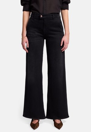 Jeans anchos negros de mezclilla, con una cintura alta, bolsillos frontales y cierre de botón. Tejido texturizado con un acabado suave.