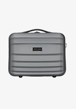 Valise rigide argentée avec texture striée, une poignée noire et une plaque de logo. Équipée de quatre roues et d'une fermeture éclair sécurisée.