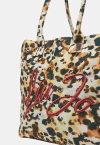 Borsa a tote con stampa leopardata e doppi manici, con logo "Liu Jo" cucito in rosso e un accento decorativo di strass. Tessuto testurizzato.