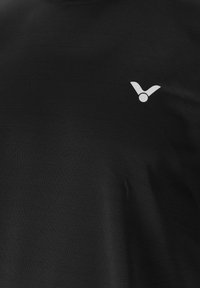 Sort T-shirt lavet af blødt bomuld, med et lille hvidt logo på brystet. Glat tekstur og enkelt crew neck design.
