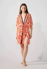 Copricostume in stile kimono arancione con motivo, dotato di vita legata, scollatura a V e maniche corte e larghe. Tessuto leggero e semitrasparente.