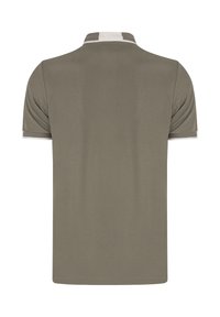 Polo de manga corta en verde oliva, con un collar y puños en blanco contrastante. Textura suave, corte clásico y diseño minimalista.