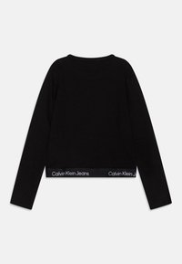Schwarzes Langarmtop mit gerippter Textur. Verfügt über einen geraden Saum und einen markierten Bund mit "Calvin Klein Jeans" in weißem Text.