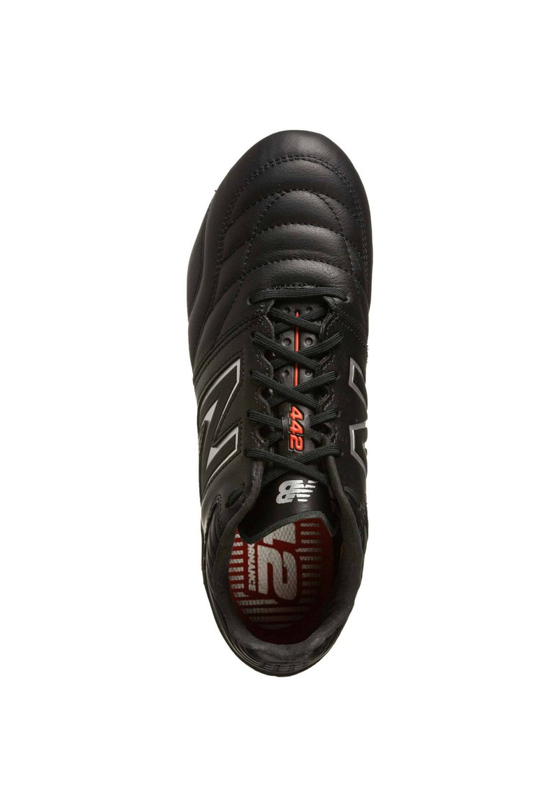 Scarpe sportive nere con tomaia cucita, materiale in pelle texturizzata, colletto imbottito e dettagli in un vivace rosso sulla linguetta e sulla soletta.