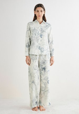 Pajama set in smooth, light fabric featuring a blue and white planetary print. The top has a collared neckline, and the pants are wide-legged.