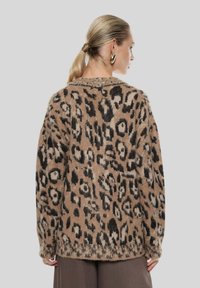 Cardigan con stampa leopardata in tonalità di marrone e nero, caratterizzato da una texture morbida, una vestibilità oversize e maniche lunghe con polsini a coste.