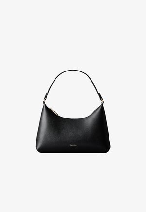 Sac à main en cuir noir Calvin Klein avec une anse courte et une fermeture éclair dorée, présenté sur fond blanc.