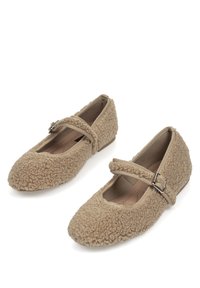 Bailarinas beige Mary Jane con un suave exterior de shearling texturizado, punta redonda y una correa con un acento de hebilla de plata. Suela plana.
