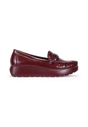 Mocasín de cuero burdeos con puntera redondeada, detalle decorativo de hebilla y acabado texturizado. Presenta una suela de goma gruesa y texturizada.
