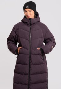 Lang, polstret lilla vinterl coats med høj krave, frontlynlås og sidelommer. Tekstureret quiltedesign med et logoaccent på ærmet.