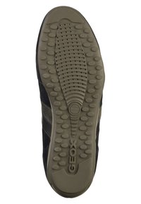 Chaussure de sport noire avec semelle en caoutchouc présentant un motif texturé et des trous de drainage. Le côté est rehauss�é d'un accent en nubuck gris foncé.