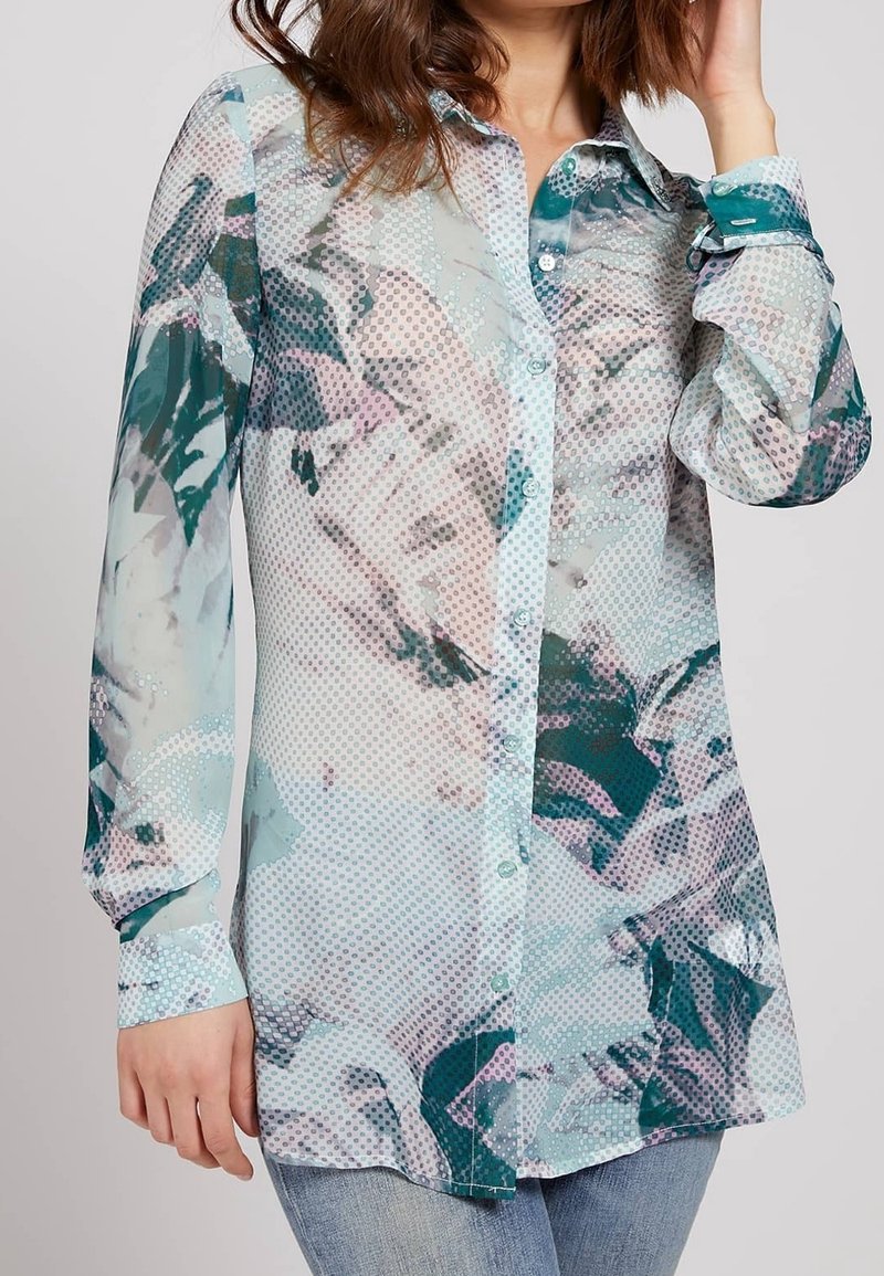 Blusa a maniche lunghe in un tessuto leggero e trasparente, caratterizzata da una stampa astratta multicolore con pois e un’apertura con bottoni davanti.