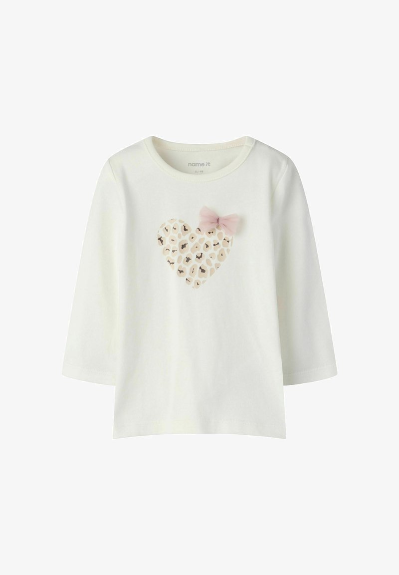 T-shirt blanc à manches longues pour tout-petit avec un cœur imprimé léopard et un petit nœud rose sur la poitrine.