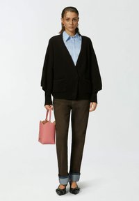 Crna rebrasta kardigan s džepovima, svijetloplava košulja s ovratnikom, tamnosmeđe hlače, ružičasta strukturirana torbica i crne cipele s mašnama.