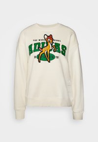 Krämfärgad sweatshirt med en tecknad grafik av en hjort, fet grön "ADIDAS" text och ribbade ärmslut och nederkant. Broderad logotypdetalj på sidan.