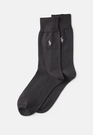 Calcetines de mezcla de algodón gris oscuro con puño acanalado, que presentan un logo bordado en cada lado. Textura suave y diseño de longitud media.