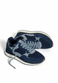 Een paar marineblauwe en grijze sport sneakers met lichtgrijze veters en witte zolen op een witte achtergrond.