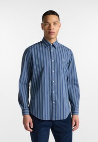 Camicia con bottoni caratterizzata da righe verticali blu e bianche, realizzata in un tessuto morbido, con colletto a punta e un piccolo logo sul petto.
