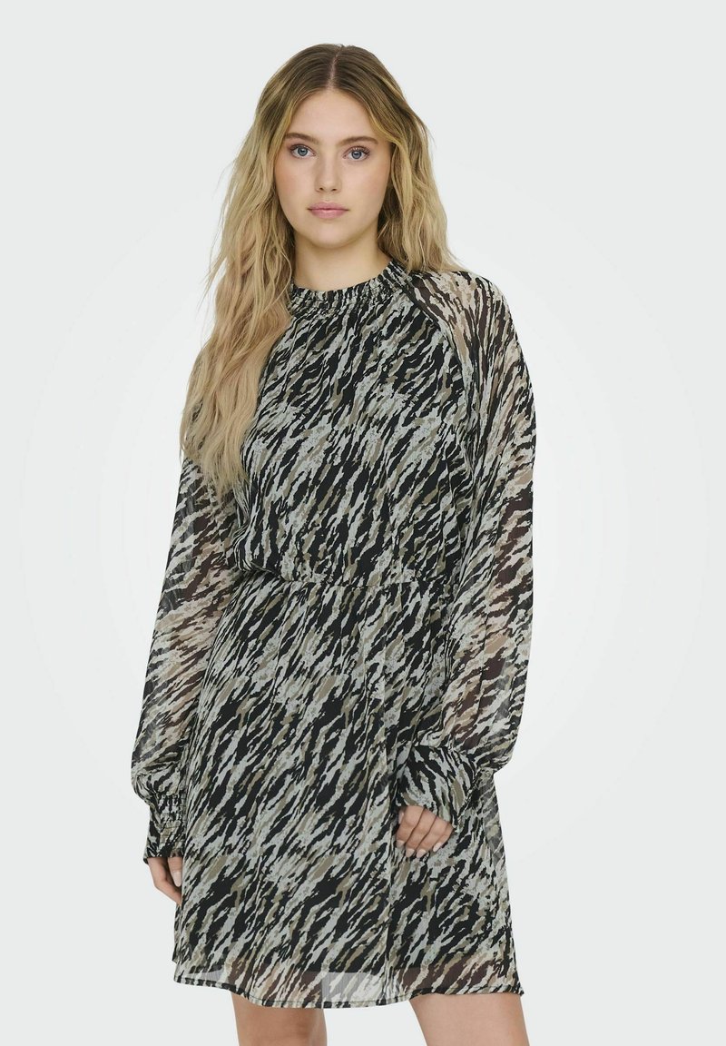 Robe à manches courtes avec un motif abstrait noir et beige. Tissu léger et fluide, décolleté froncé et détail de taille élastique.