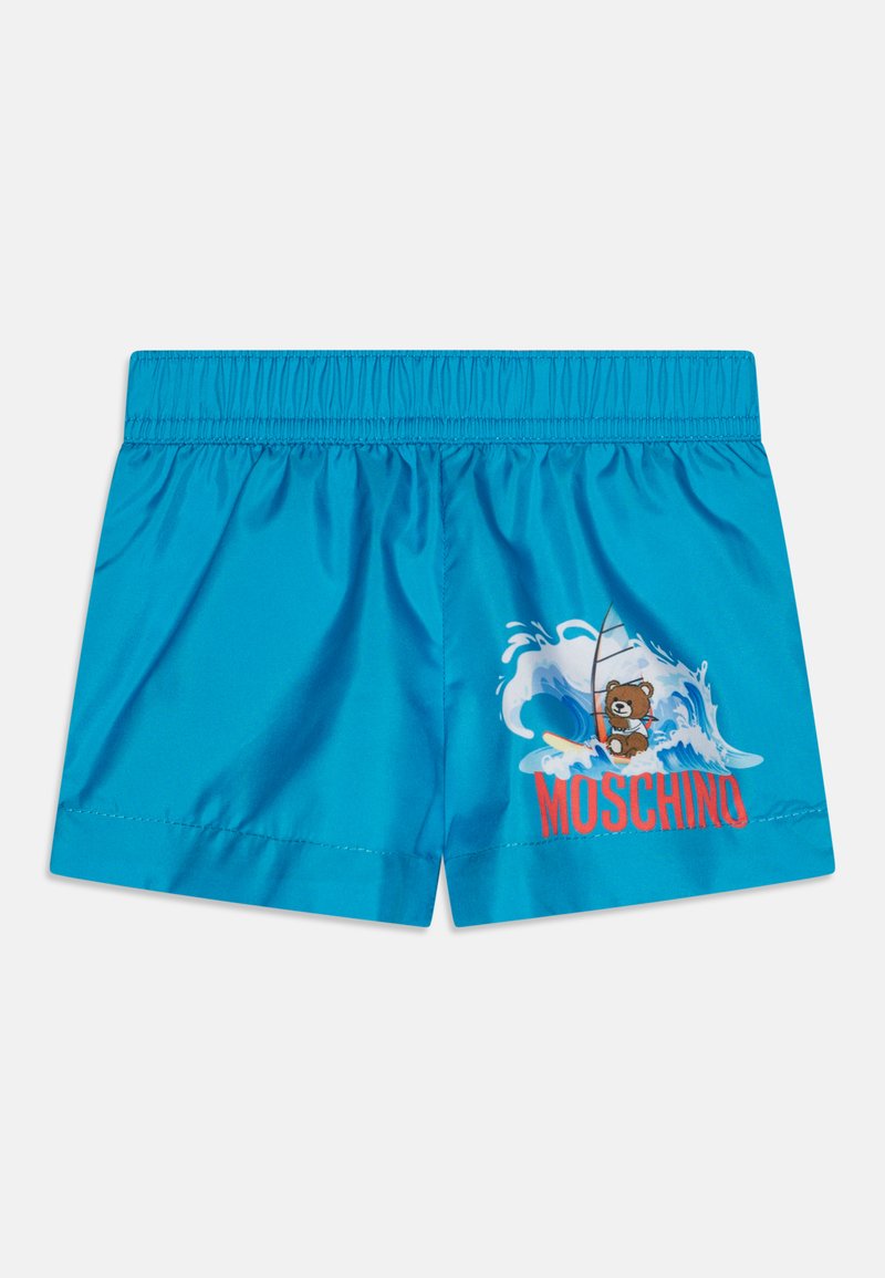Bañador azul con cintura elástica, que presenta una gráfica de un oso surfeando en una ola. "Moschino" impreso en rojo. Textura de tela suave.