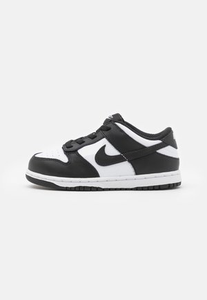 Czarno-biały niskoprofilowy sneaker ze sznurowadłami i logo Nike Swoosh z boku, pokazany od zewnętrznej strony na białym tle.