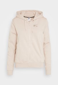 Beige zip-up hoodie i mjukt tyg, med en framlogo, två sidofickor och en huva med dragsko, samt ribbad nederkant och ärmslut.