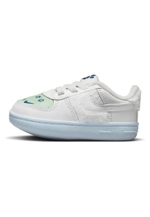 Biały i jasno-niebieski dziecięcy sneaker z wzorem śladu łapy na czubku, miękką wyściółką kołnierza oraz logo Nike Swoosh po boku i na podeszwie.