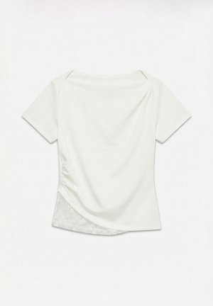 Valge naiste lühikeste varrukatega topp asümmeetrilise äärega, kerge voldistus ühelt poolt ja pitsdetail alumises vasakus seljaosas.