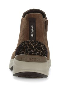 Bruine suède enkelboot met een zwart panterprintaccent, een rits aan de zijkant en een gevoerde beige zool. "Rollingsoft" logo op de achterkant.
