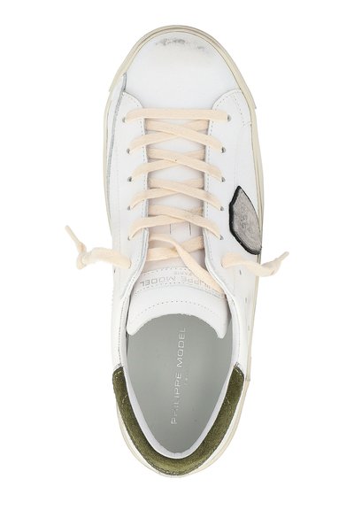 Zapatilla blanca de cuero con cordones color crema, detalles plateados y un talón de ante verde. Presenta un revestimiento texturizado y un diseño de punta redonda.