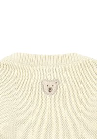 Cremefarbener Strickpullover mit strukturierter Oberfläche und kleinem, gesticktem Bärenkopf auf der Vorderseite. Rundhalsausschnitt mit geripptem Abschluss.