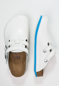 White clogs with a smooth, textured finish, featuring two adjustable straps, metallic accents, and a blue accent on the outsole.