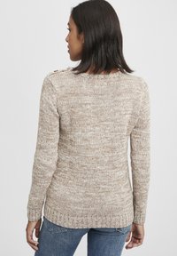 Hellbrauer Strickpullover mit strukturiertem Muster, langen Ärmeln und Rundhalsausschnitt. Mit Rippbündchen an den Ärmeln und am Saum.