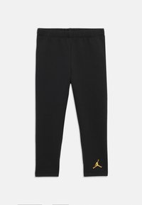 Leggings negre dintr-un material elastic, cu o talie elastică. Prezentă un mic logo Jumpman de culoare aurie aproape de gleznă.