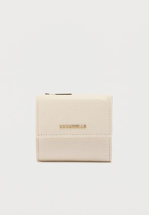 Kompakt cremefarvet læderpung med tekstureret finish og guld COCCINELLE-logo på frontklappen, sat op mod en ensfarvet baggrund.