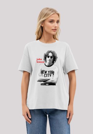 White cotton t-shirt featuring a graphic of a man with sunglasses and curly hair, text reading "john lennon" in red and "NEW YORK CITY" in bold black.
