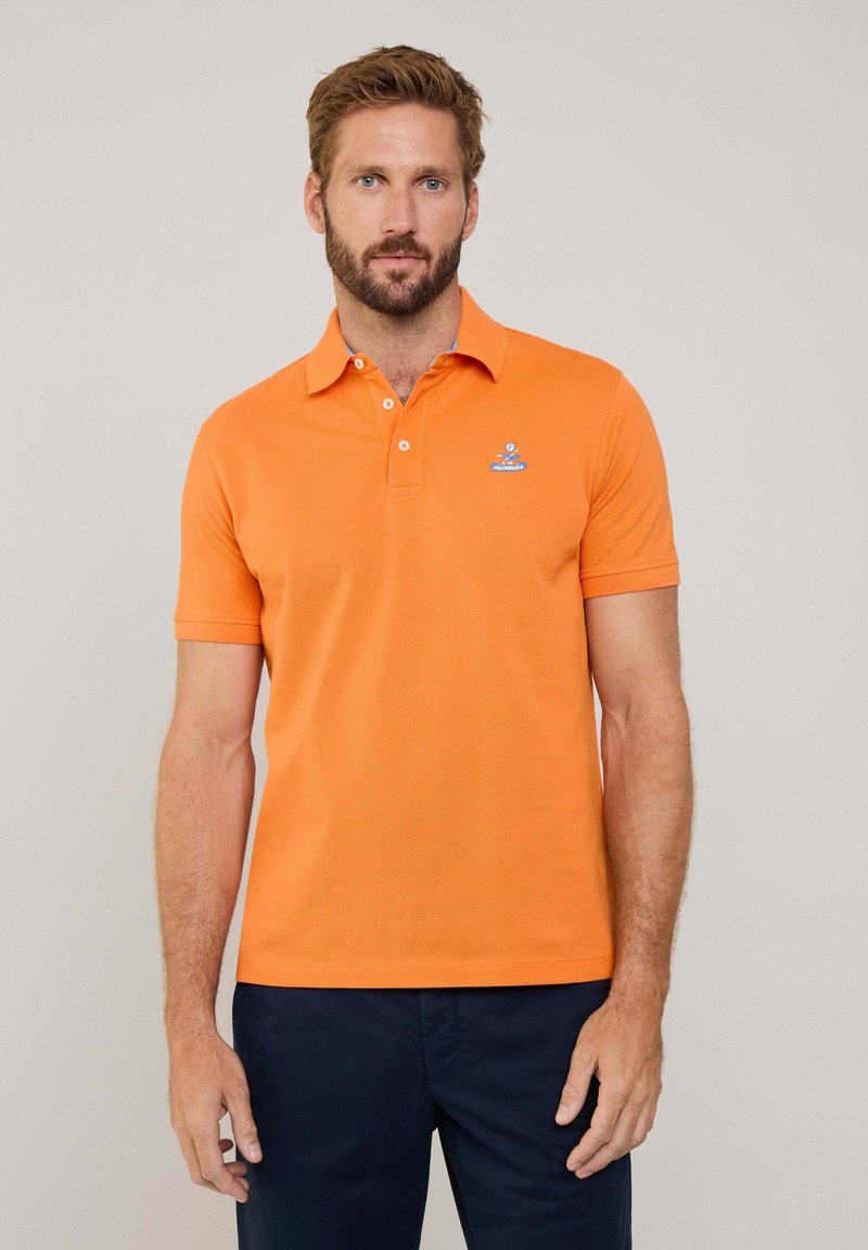 Polo arancione realizzato in cotone, con colletto e maniche corte. Presenta un piccolo logo blu ricamato sul petto.