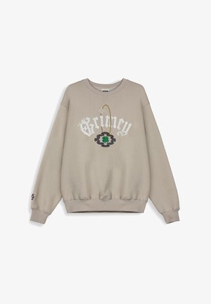 Sudadera beige con mangas anchas, puños y dobladillo acanalados. Presenta el lettering "Grimey" y un diseño de trébol en bordado verde y azul.