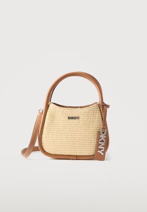 Μικρή μπεζ υφαντή τσάντα χειρός με καφέ δερμάτινες λεπτομέρειες, στρογγυλή λαβή, αφαιρούμενο λουρί και ασημένιο λογότυπο DKNY στο μπροστινό μέρος και στην ετικέτα.