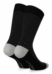 Czarne skarpetki z białym kropkowanym wzorem, z szarymi akcentami na pięcie i palcach. Wykonane z miękkiego, elastycznego materiału o gładkiej teksturze.