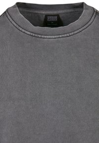 Sudadera gris con cuello y puños de canalé, que presenta una textura suave y un tejido fino. La etiqueta dice "URBAN CLASSICS," talla M.