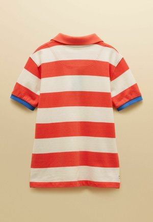 Punaste ja valgete horisontaalsete triipudega lühikeste varrukatega polo särk sinise äärisega varrukaservadel, tagantvaates beežil taustal.