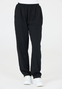 Zwarte joggingbroek van zachte stof, met een elastische tailleband en zijzakken. Ontworpen voor comfort met een ruime pasvorm.