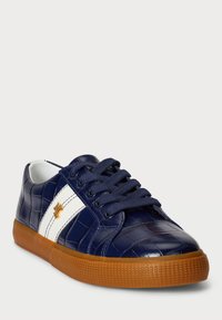 Jūras zilas krokodila rakstu sporta apavi ar baltu svītru, brūnu gumijas zoli un apaļu purngalu. Iespējas: teksturēta virsma un sašņorēšana.